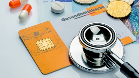 Stethoskop mit Krankenversicherungskarte und Tabletten